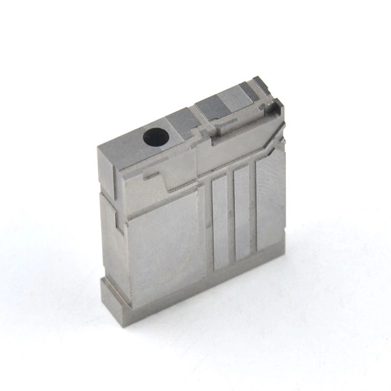 Rectangular machined metal component with a circular hole, stepped surfaces and detailed side features